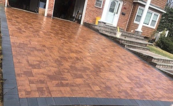 A brick driveway with stairs leading up to a house.