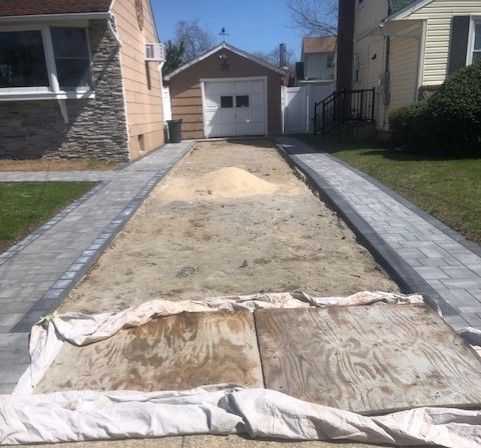 A driveway is being built in front of a house.