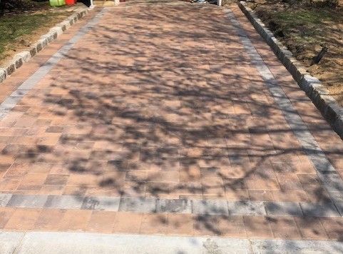 A brick walkway with a tree shadow on it.