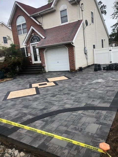 A large house with a brick driveway in front of it.