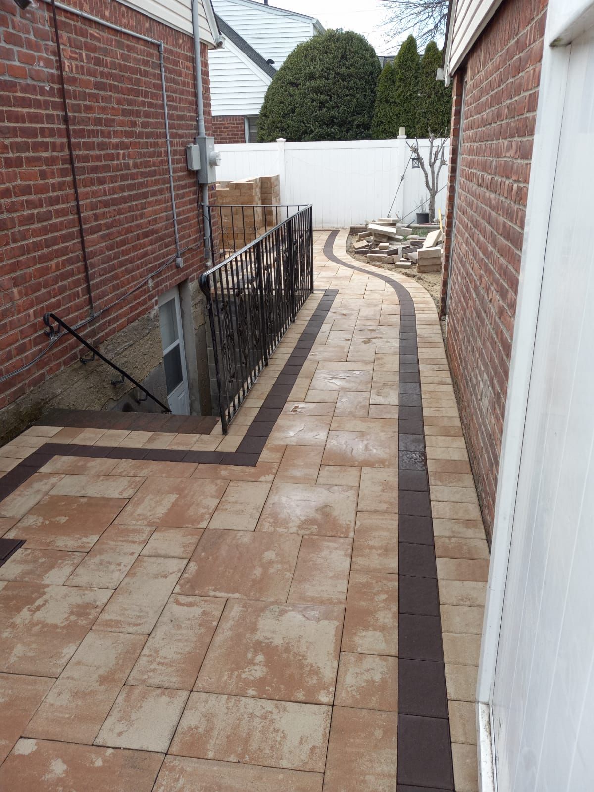 A brick walkway leading to the basement of a house