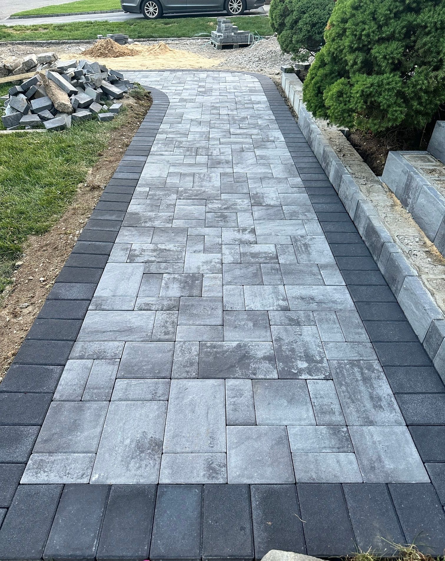 A brick walkway is being built in front of a house.