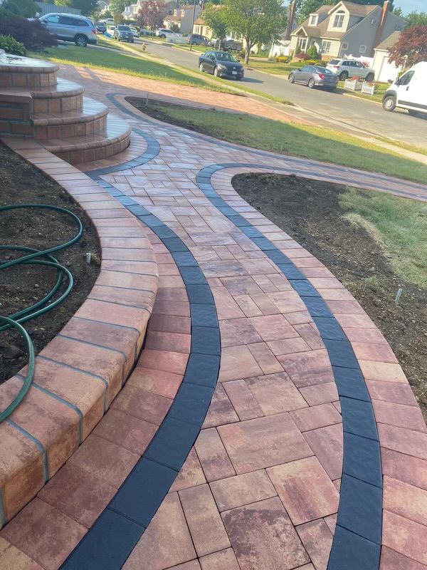 A brick walkway with steps and a hose on the side of it.