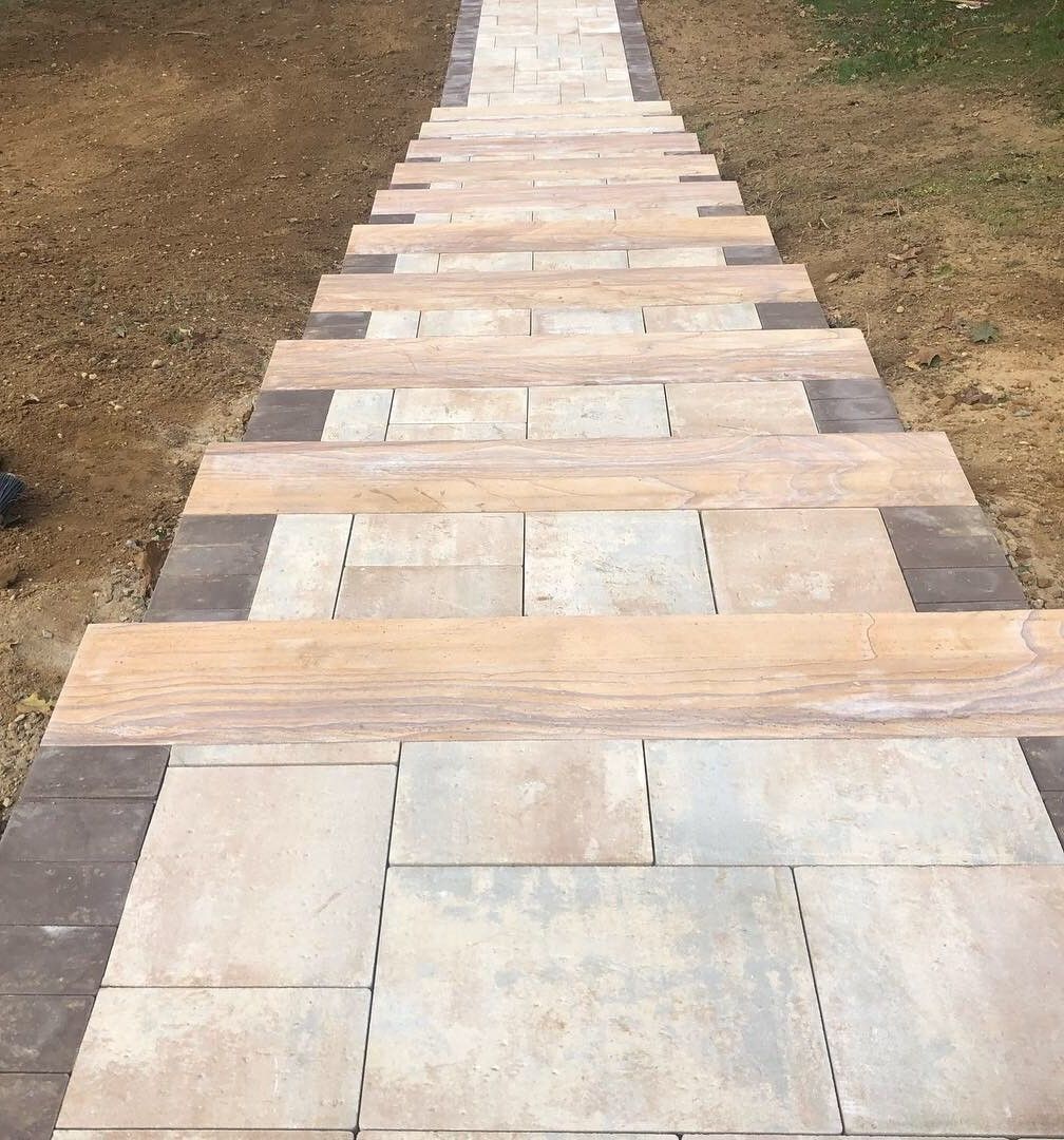 A walkway made of tiles and wood looks like a wooden bridge.
