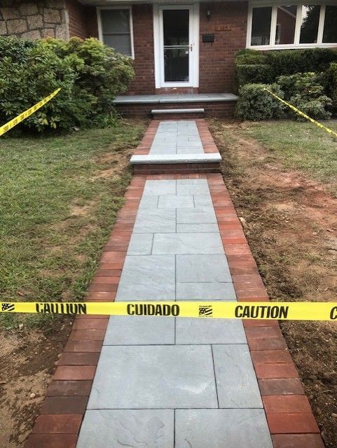 A walkway is being built in front of a brick house
