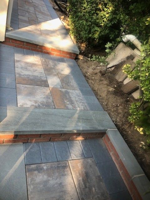 A brick walkway with steps leading up to a house.