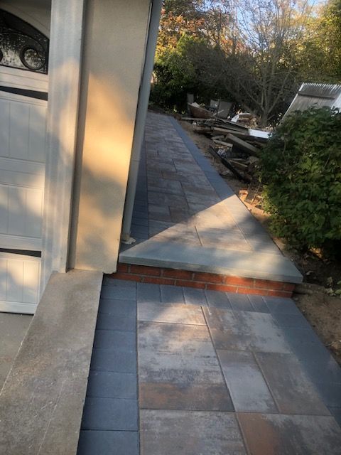 A sidewalk is being built next to a garage door.