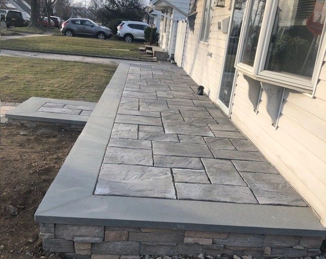 A stone walkway is being built in front of a house.