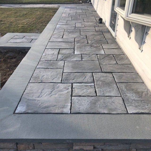 A stone walkway leading to a house with a window