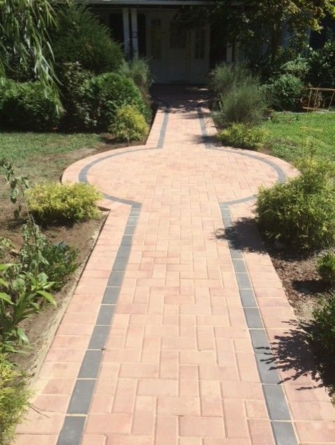 A brick walkway leading to the front door of a house.