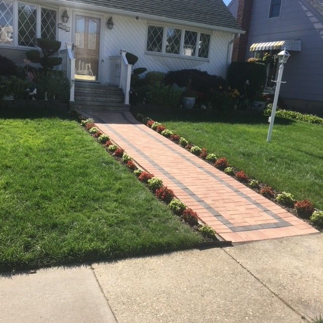 A white house with a brick walkway leading to it