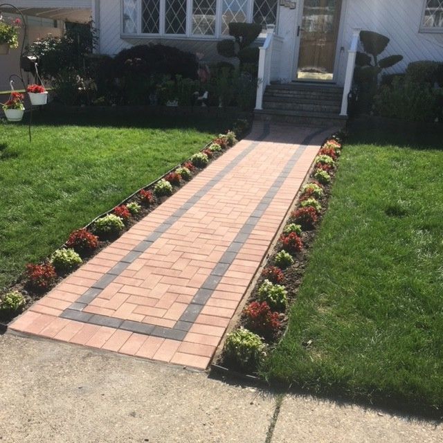 A brick walkway leading to the front door of a house