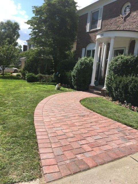 A brick walkway leading to a brick house