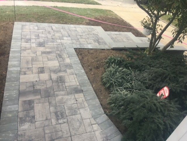 A brick walkway is being built in front of a house.