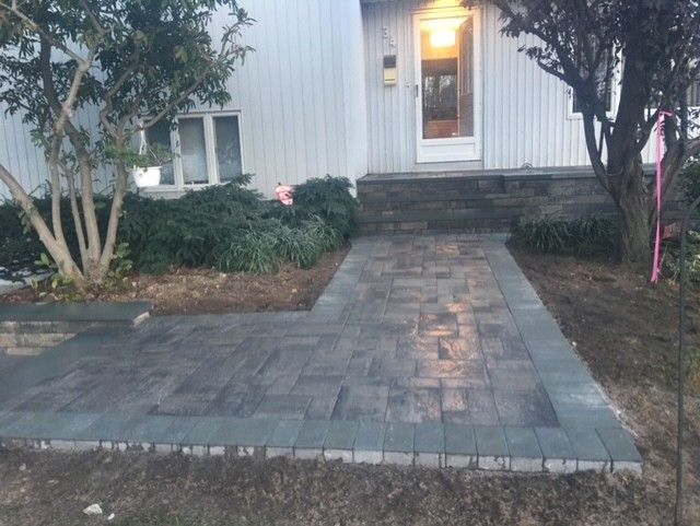 A brick walkway leading to the front door of a house