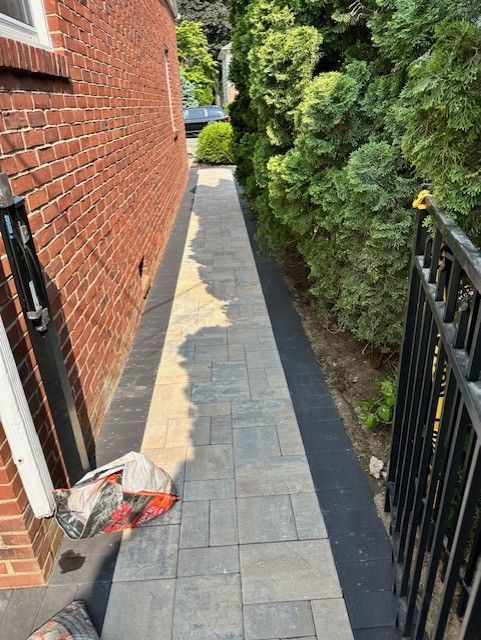 A sidewalk is being built next to a brick building.