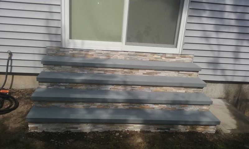 A set of stairs leading up to a house with a sliding glass door.