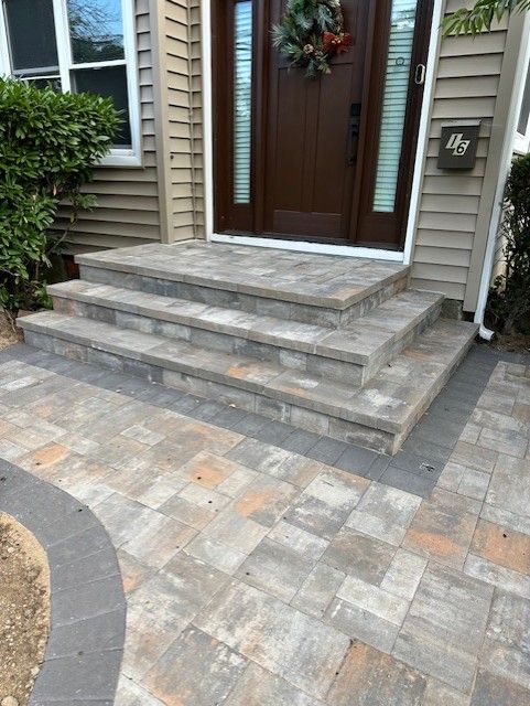 A front porch with stairs leading up to the front door of a house.