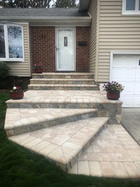 A house with stairs leading up to the front door and a garage.