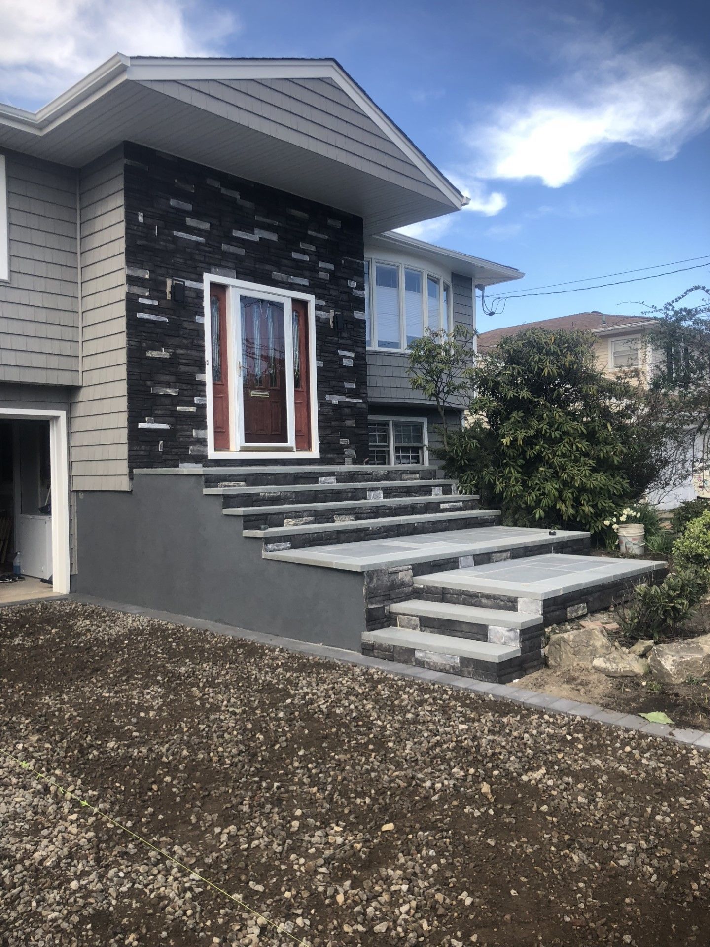 A house with stairs leading up to the front door.