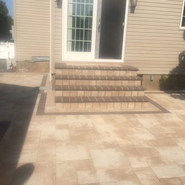 A house with a patio and stairs in front of it.