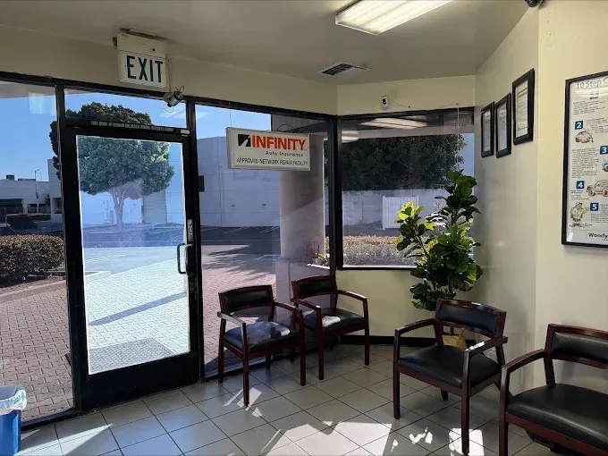 Office lobby with glass door, EXIT sign, chairs, plant, and INFINITY logo sign