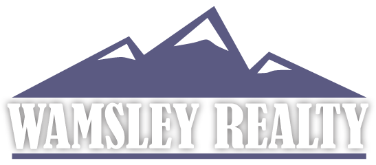 A logo for a real estate company called vamsley realty