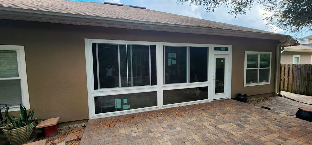 Backyard patio with a screened porch and brown siding.