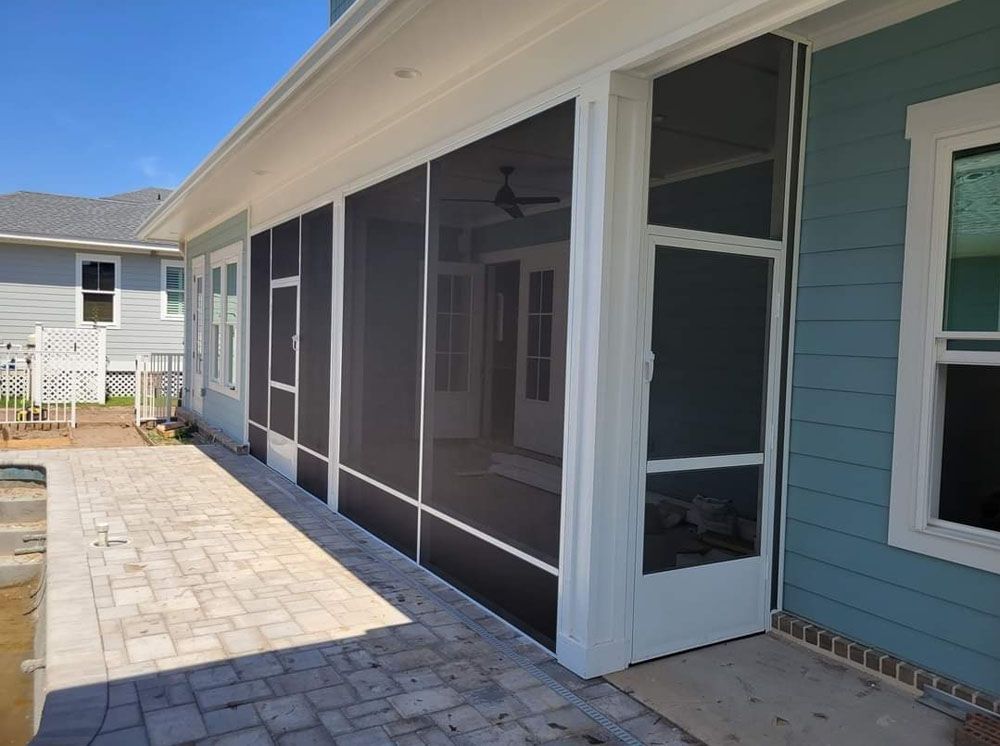 Screened porch with white frame, blue siding, brick patio, and a view of the interior.