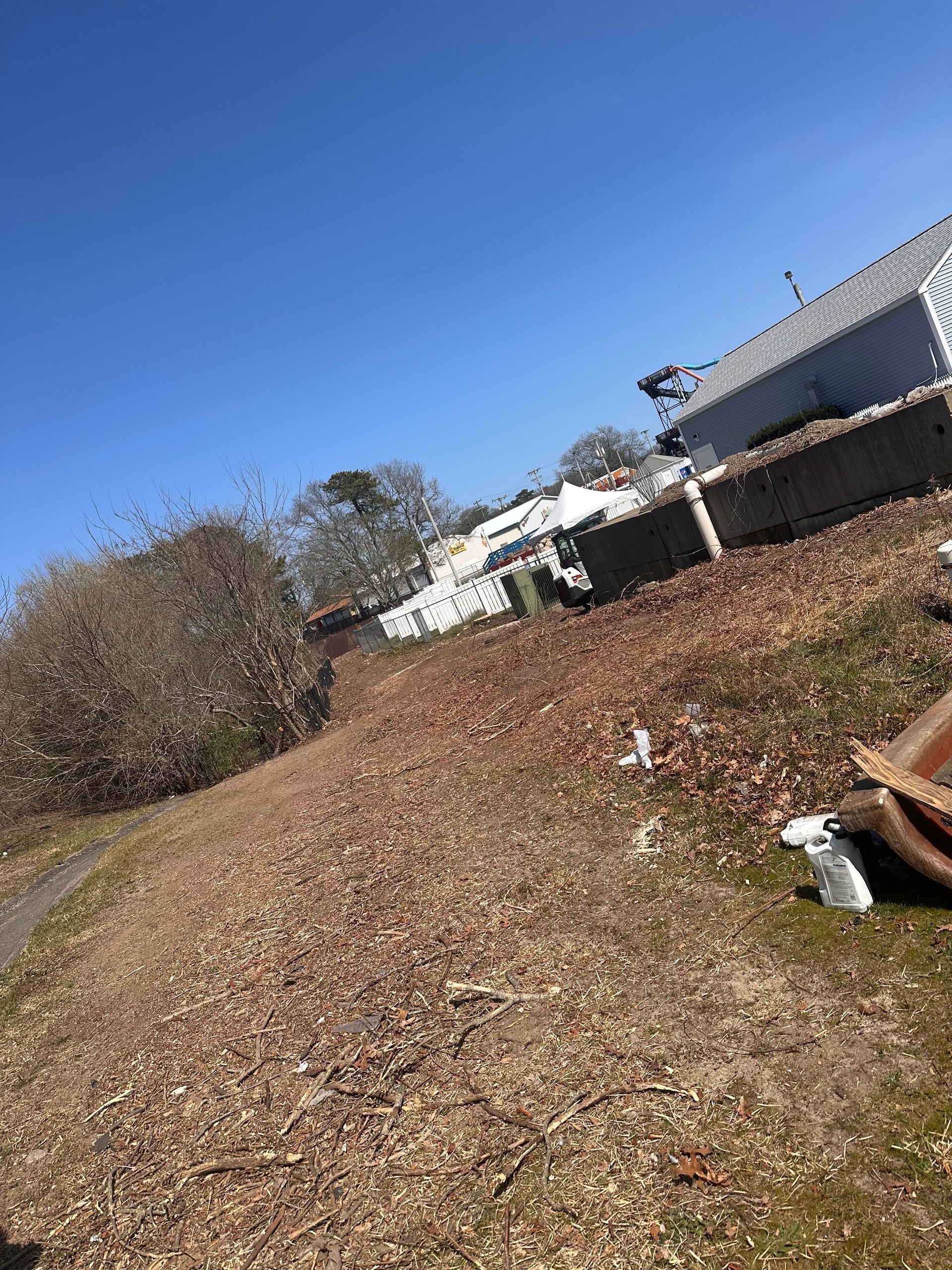 A person is laying on the ground in a field with a blue sky in the background.