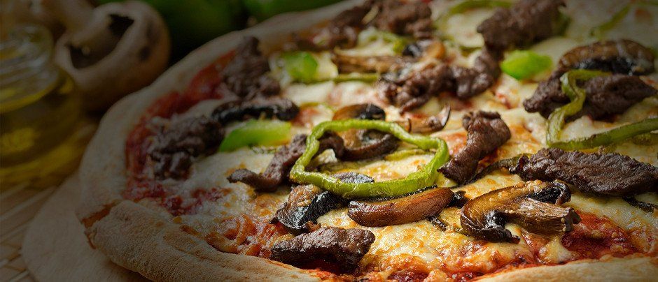 A delicious steak and mushroom pizza with green peppers and olive oil