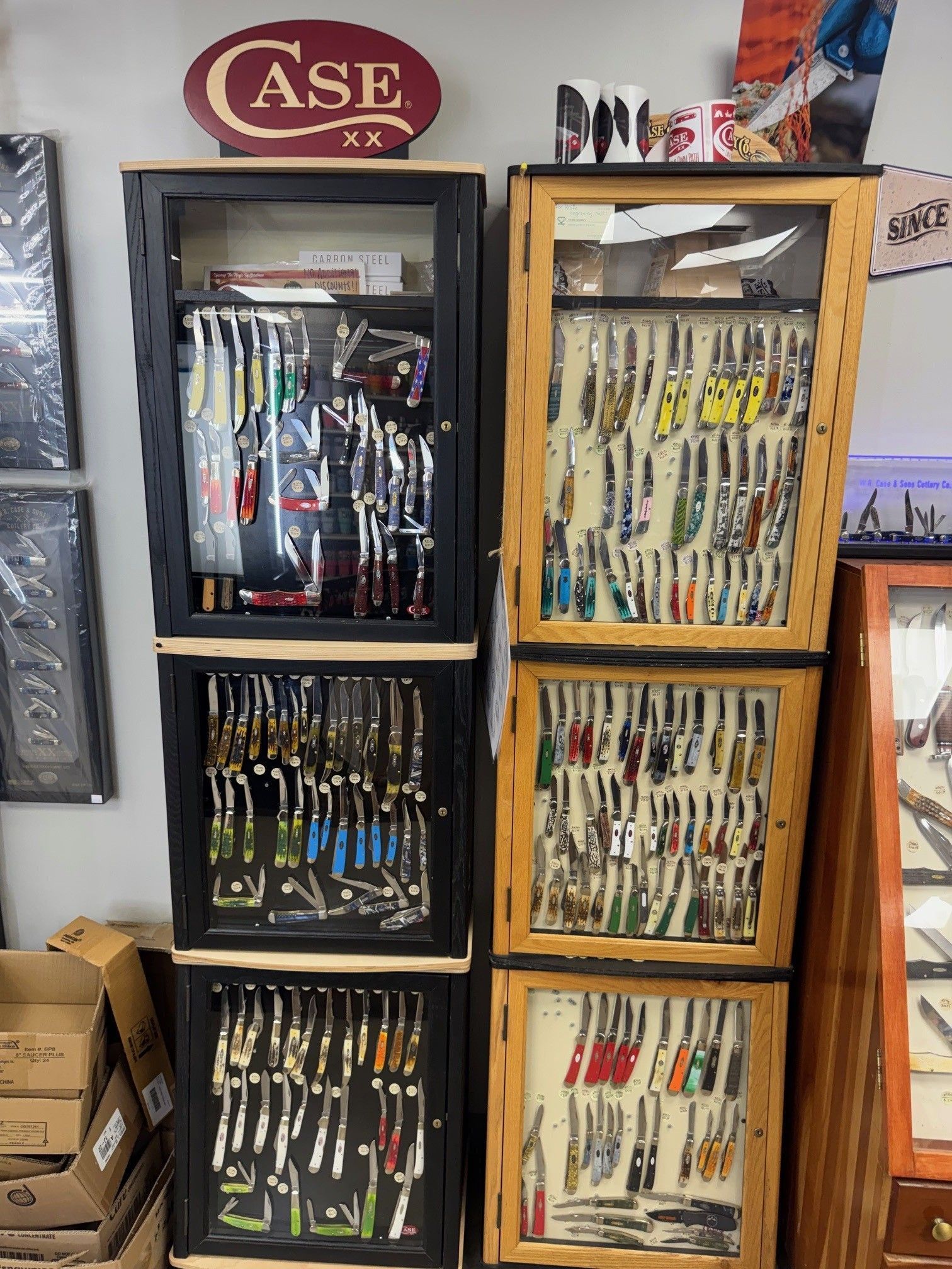 Two vertical stacks of glass display cases filled with various pocket knives under a Case XX brand sign.
