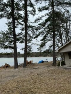 A house is sitting next to a lake surrounded by trees
