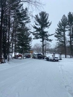 A lot of cars are parked in the snow in a parking lot