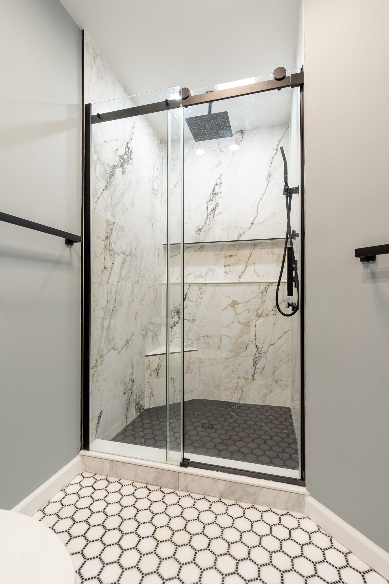 A bathroom with a walk in shower with a sliding glass door.