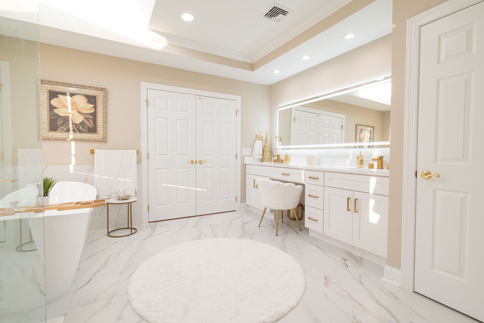 A bathroom with a tub , sink , mirror and rug.