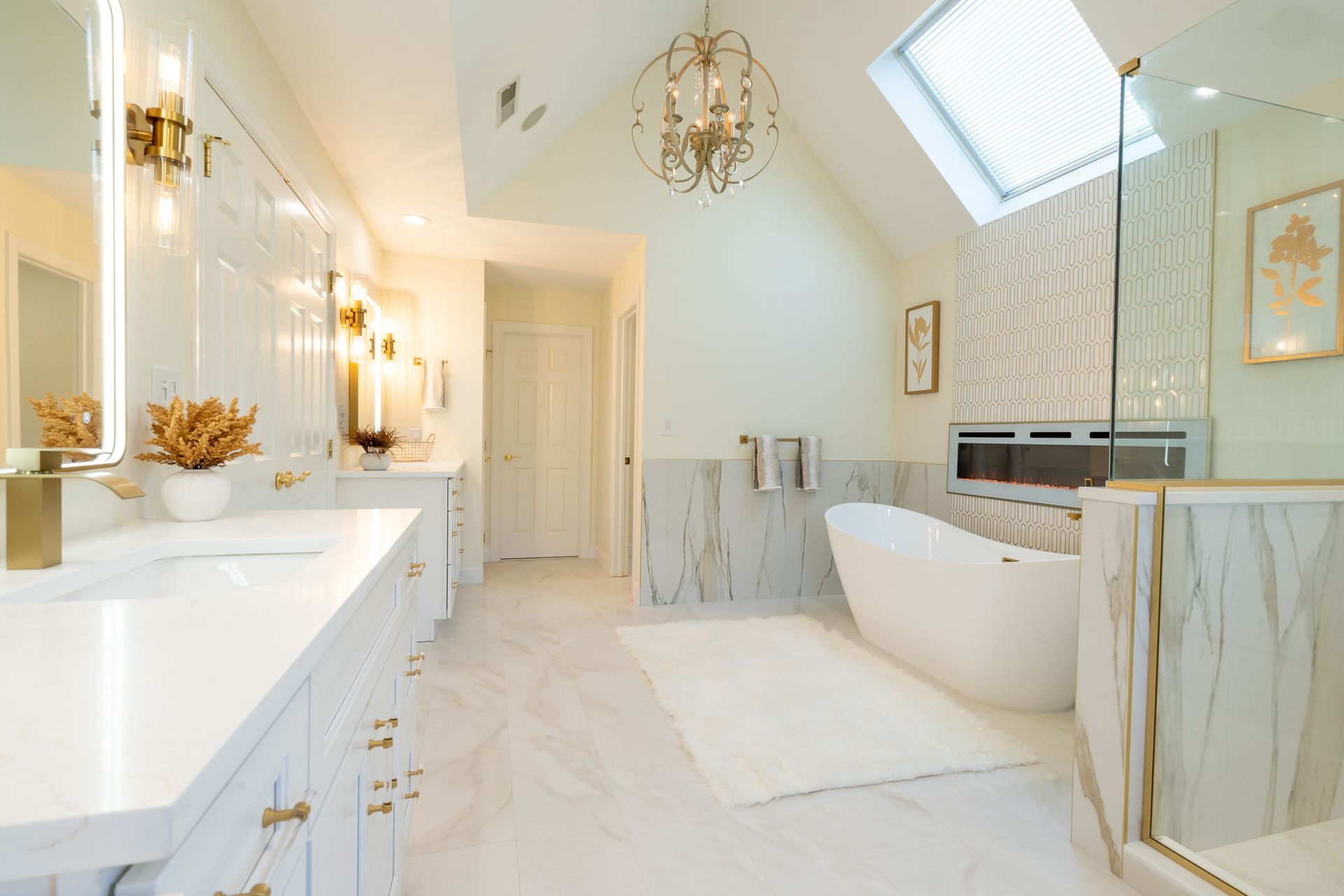 A bathroom with a tub , sink , mirror and skylight.
