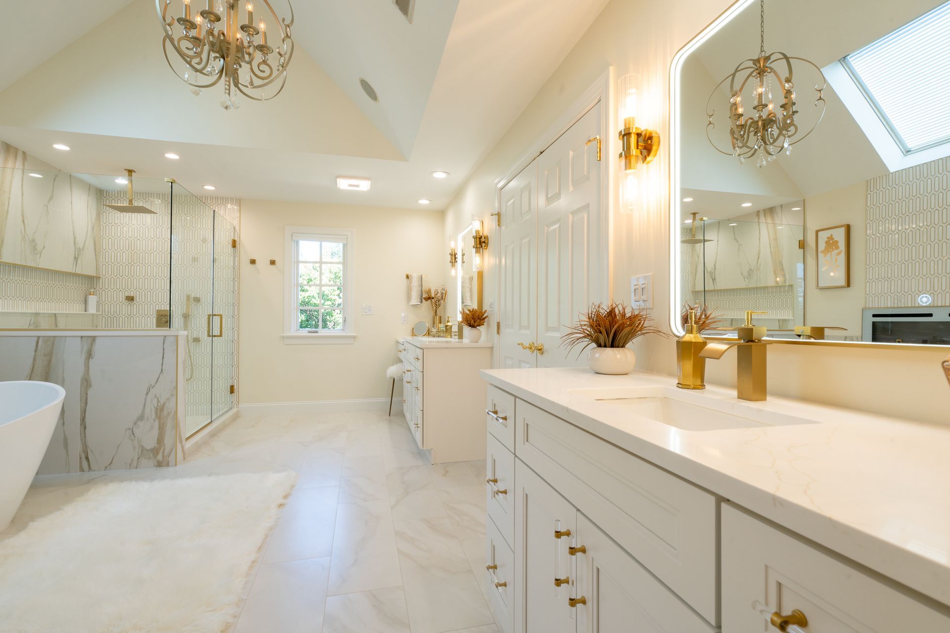 A bathroom with two sinks , a tub , a mirror and a chandelier.