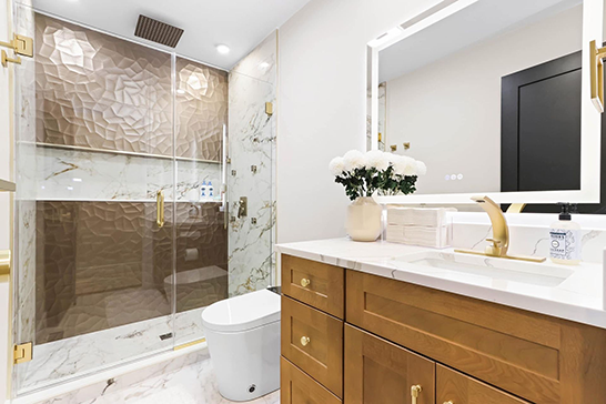 A bathroom with a toilet, sink, mirror, and walk-in shower.