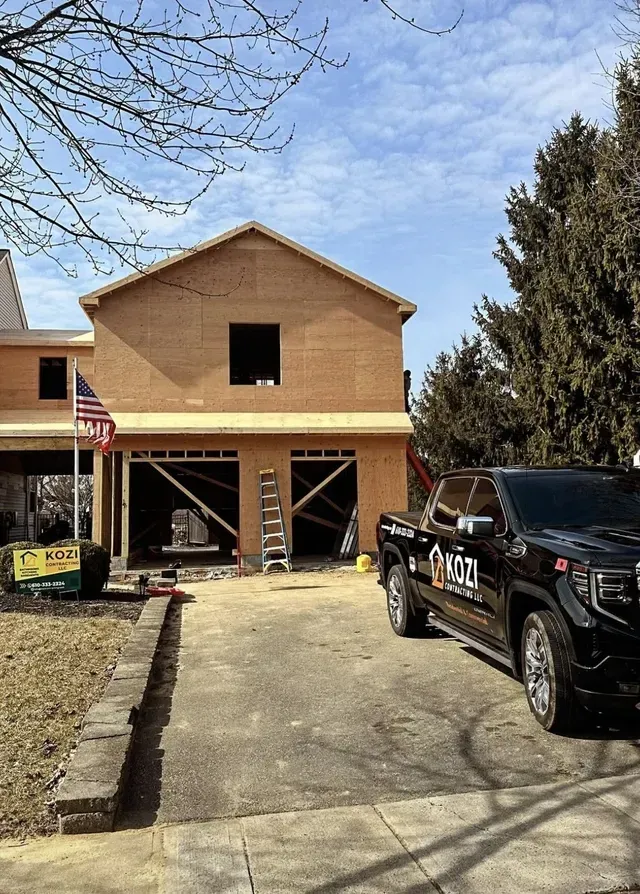 A truck is parked in front of a house under construction.