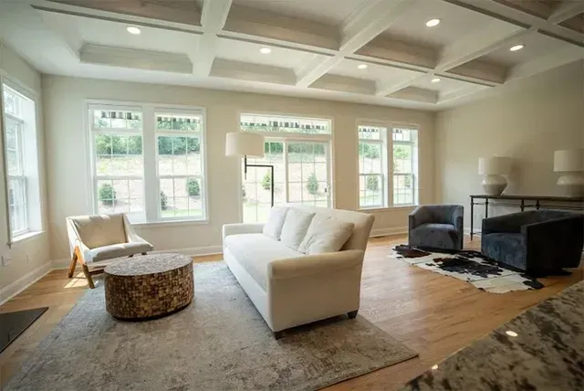 A living room with a couch, chairs, and a rug