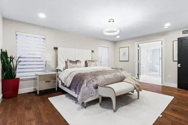 A bedroom with a king size bed and a bench