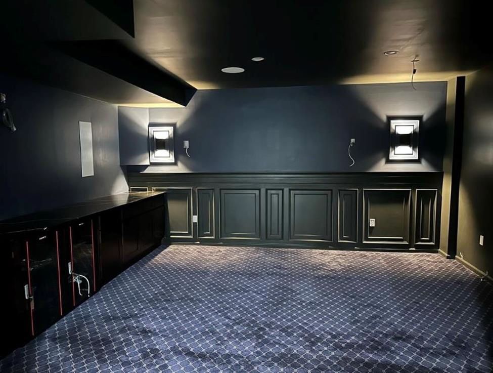 A dark room with a blue carpet and black walls
