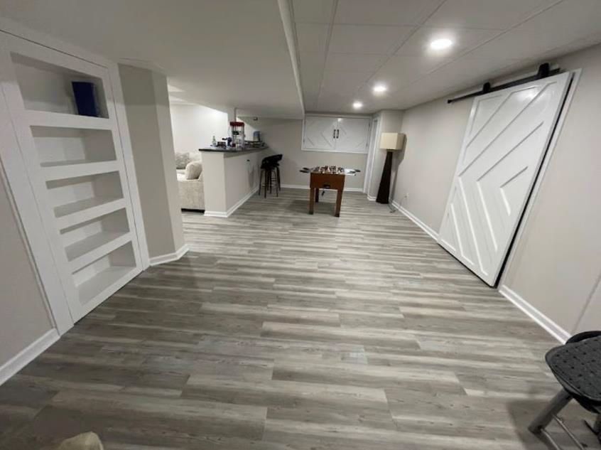 A basement with a sliding barn door and a foosball table