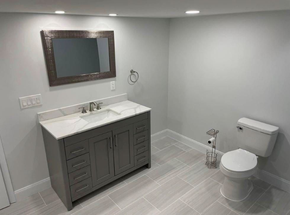 A bathroom with a sink, toilet and mirror