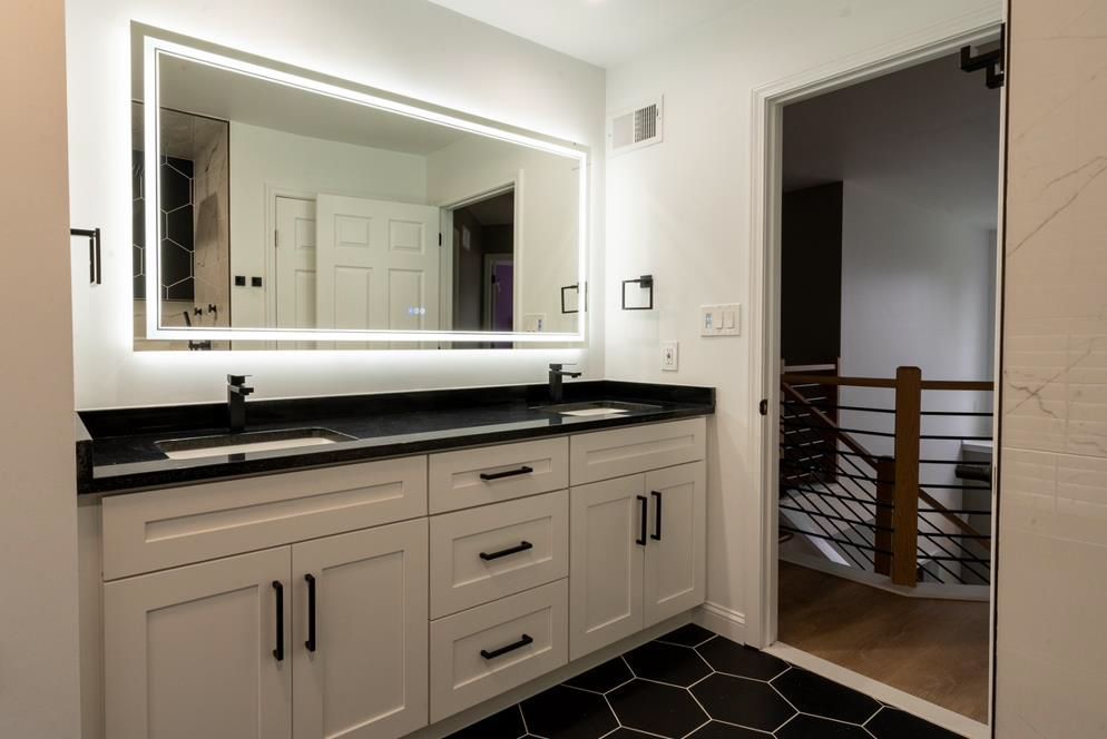 A bathroom with two sinks and a large mirror
