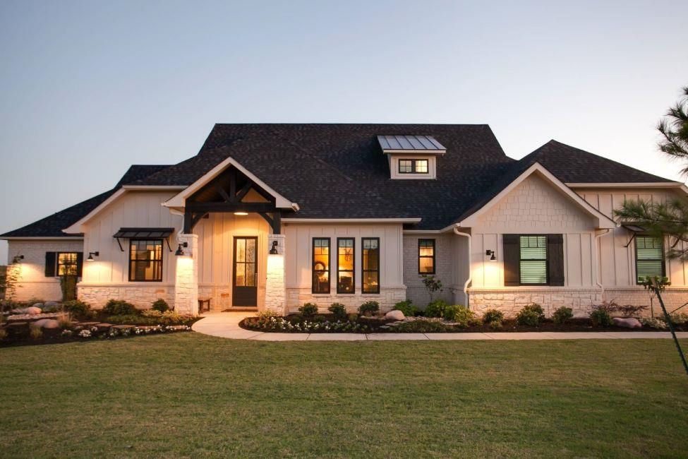 A large white house with black shutters and a black roof