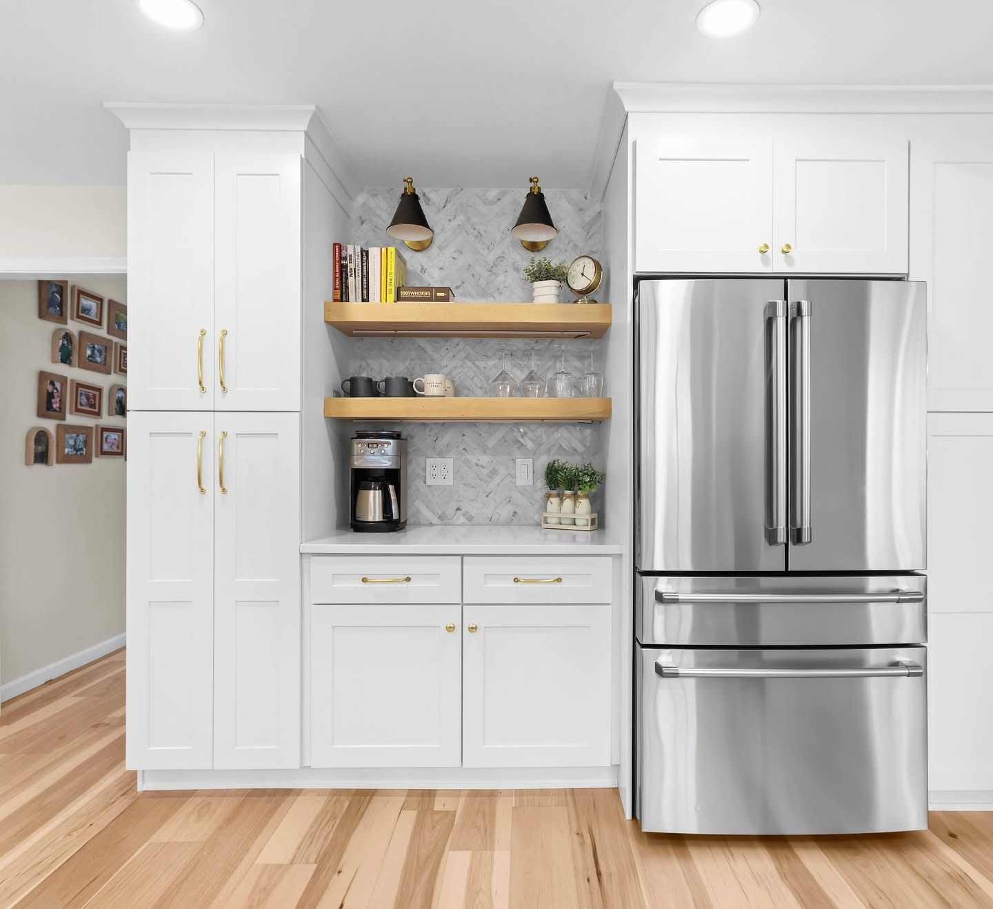 A kitchen with white cabinets and a stainless steel refrigerator.