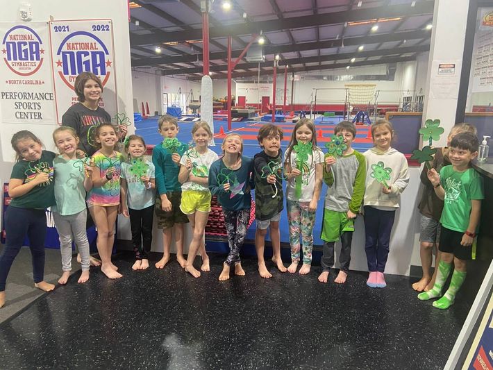 A group of children are posing for a picture in a gym.