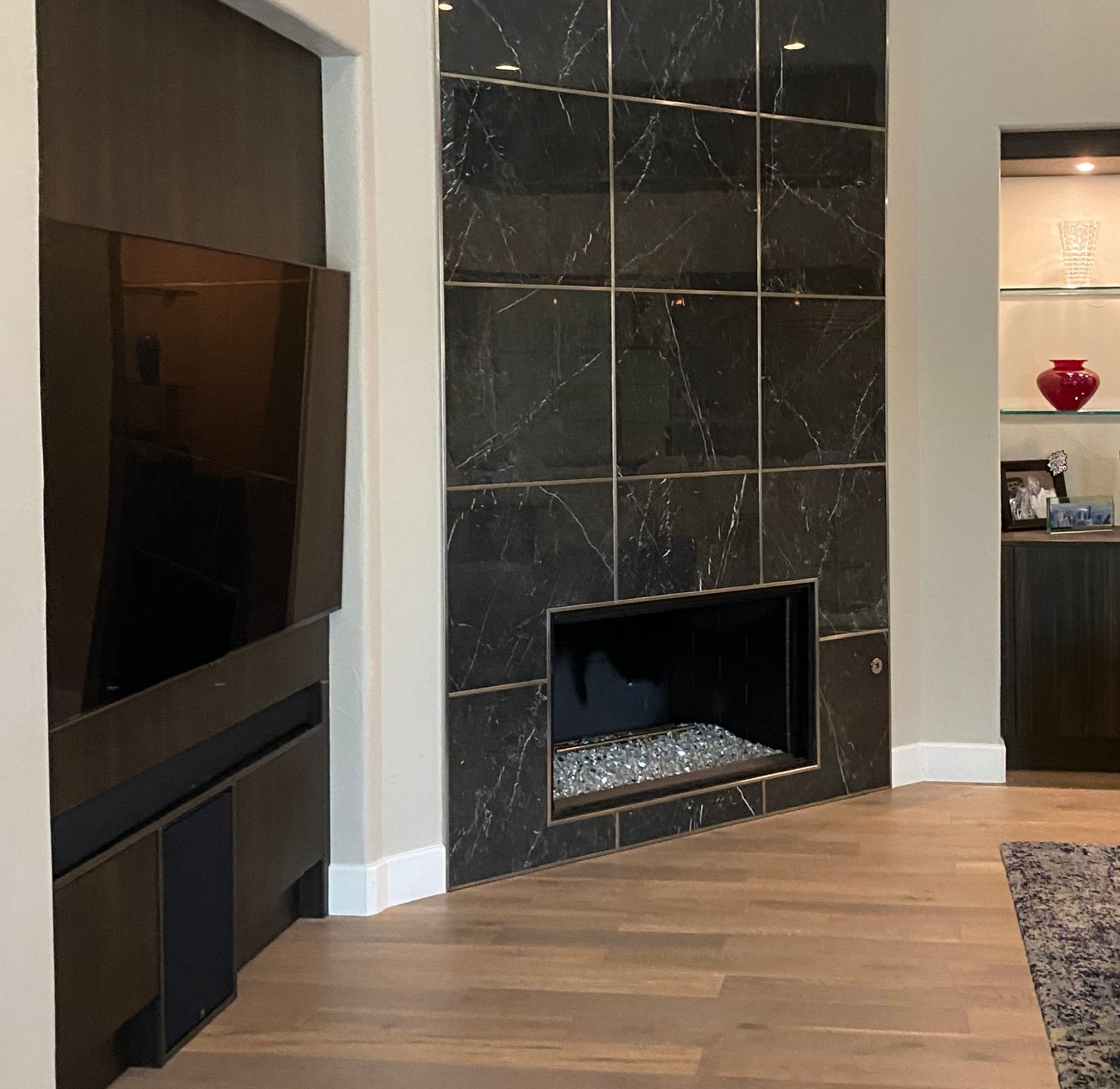 Modern living room with black marble fireplace and built-in TV.
